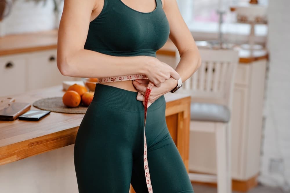 Woman measuring her waist for medical weight loss