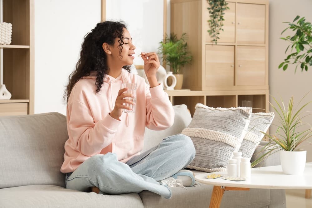 Woman taking wellness supplements at home